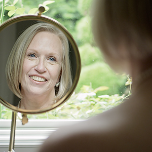 woman looking in mirror after facelift