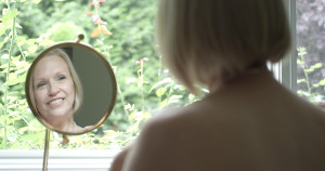 woman looking in mirror facial